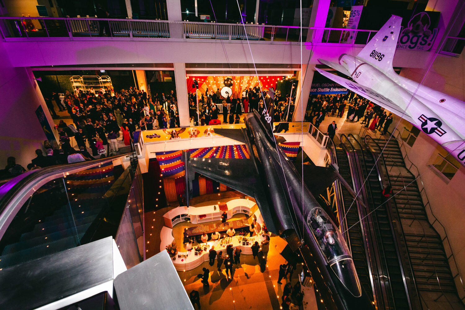 Aerial view of carnival themed cocktail party in the Ahmanson Building with purple and amber lighting at dusk