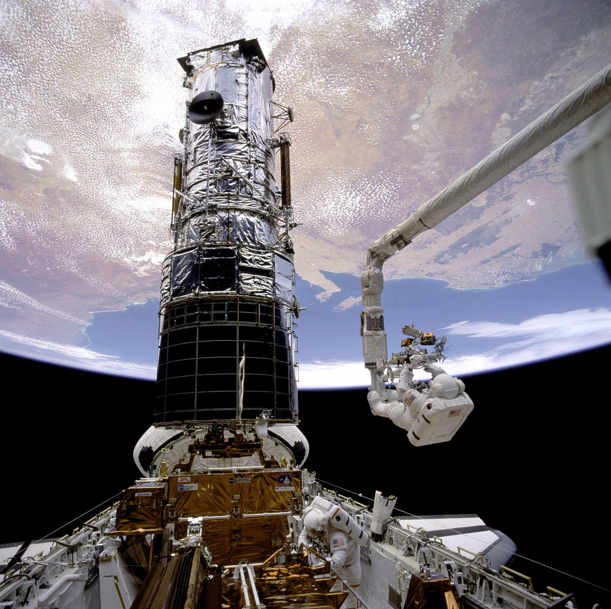 Endeavour astronauts repairing the Hubble Space Telescope in space