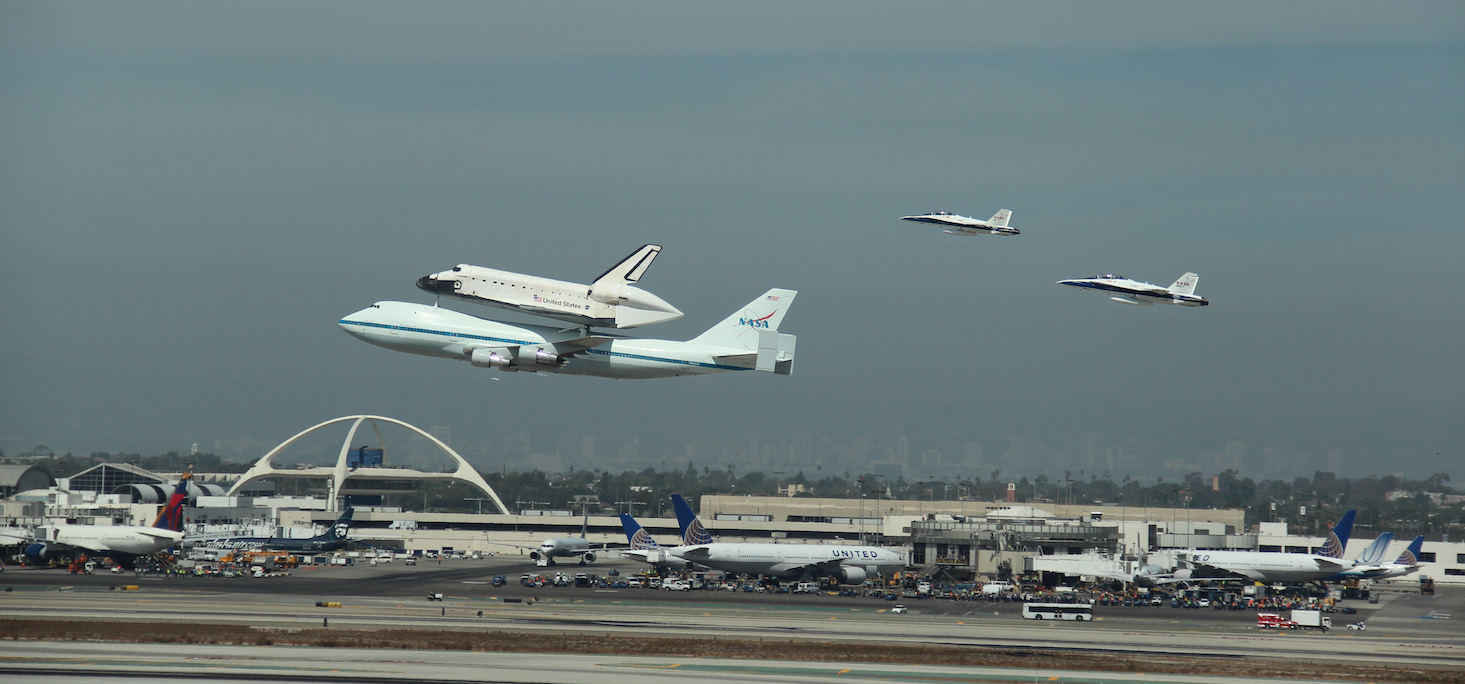 Endeavour flies past LAX atop the Shuttle Carrier Aircraft with F/A-18 chase planes
