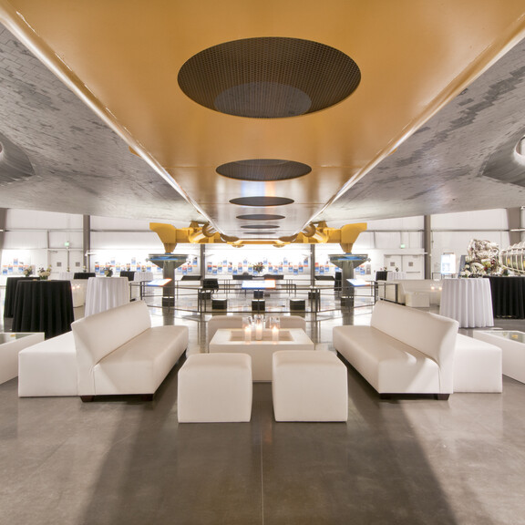 White event lounge furniture under the belly of the Space Shuttle Endeavour