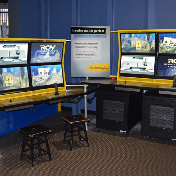 Two screen-based remote-operated vehicle simulation stations, each paired with two joysticks