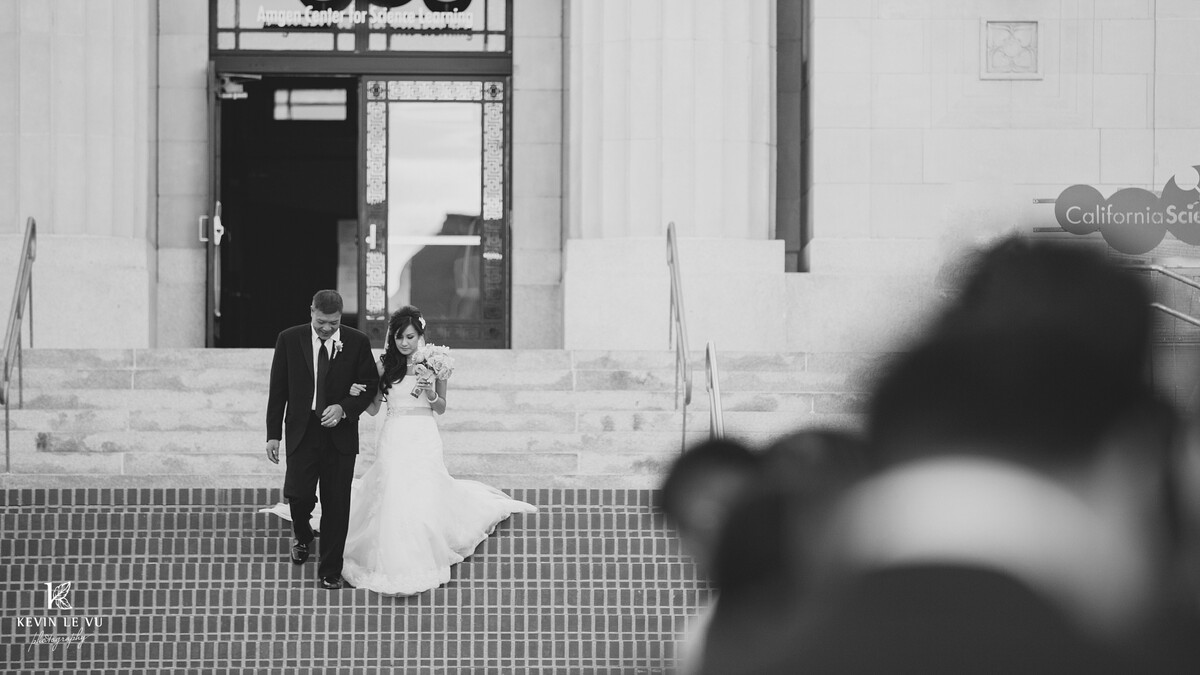 A bride is escorted down the Wallis Annenberg Building steps by her father to walk her down the aisle.