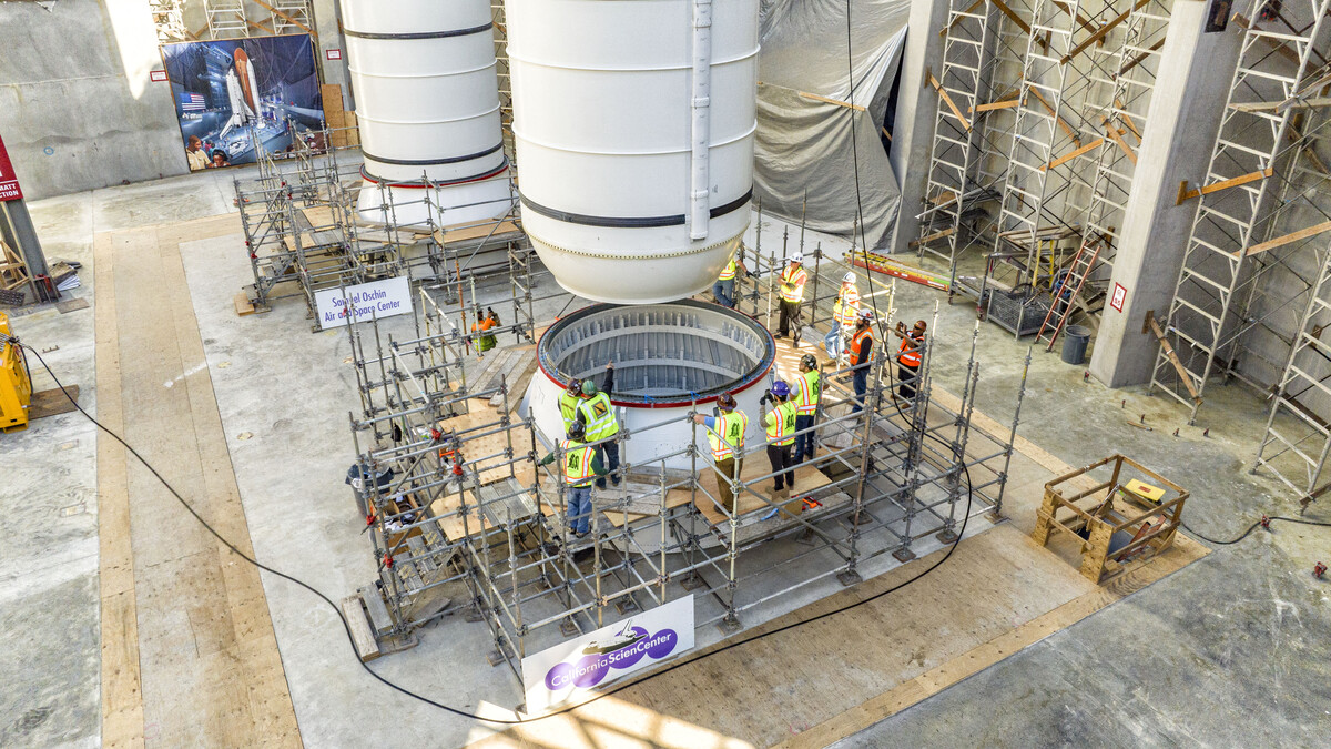 Construction workers stand inside the construction site of the future Samuel Oschin Air and Space Center as the solid rocket motors are being installed.