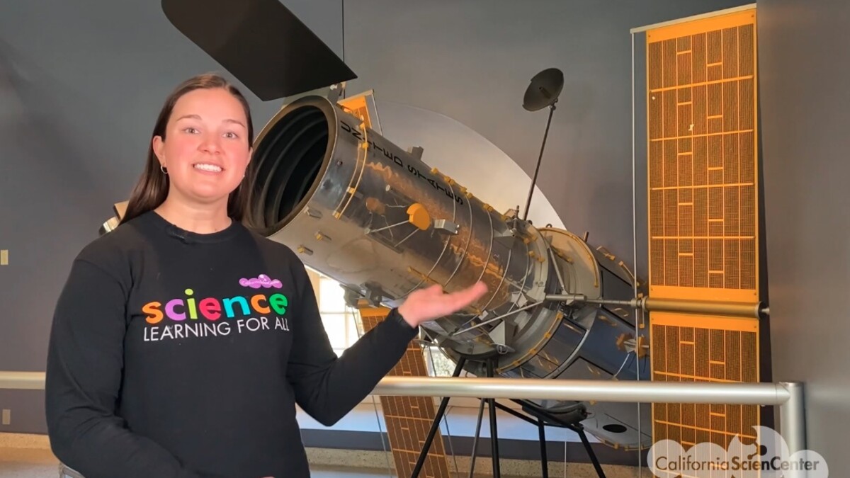 Educator Elaine in front of telescope