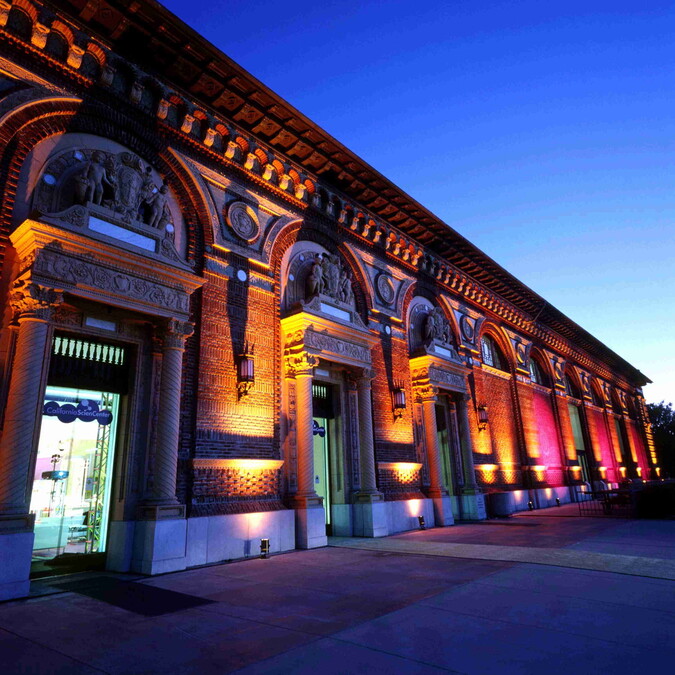 California Science Center rear entrance and North Patios illuminated in amber and pink uplights