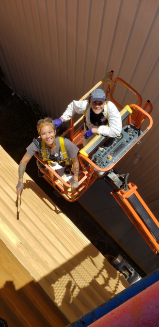 Team members Anne and Devin paint the intertank section of the external tank.