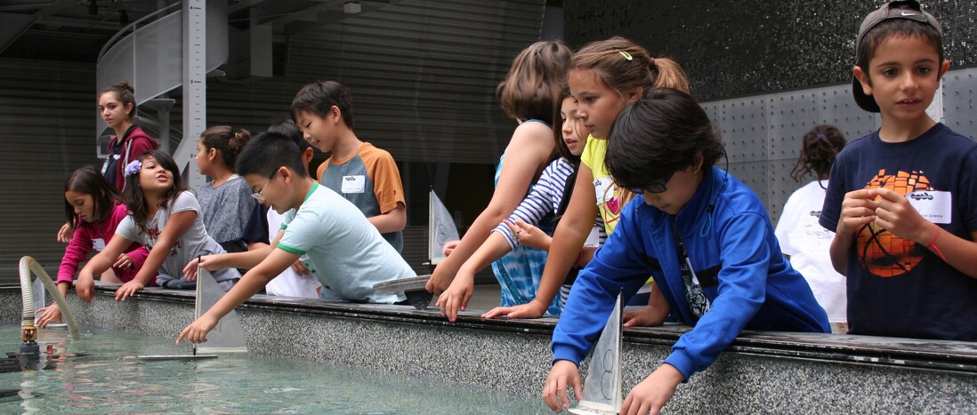 Youth participating in a field trip program, testing boats in the Water Works pool